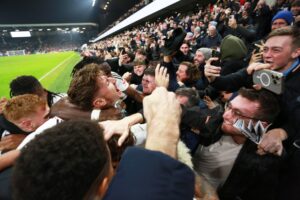 Alex Iwobi, Calvin Bassey and Harry Wilson celebrate with the Fulham fans.